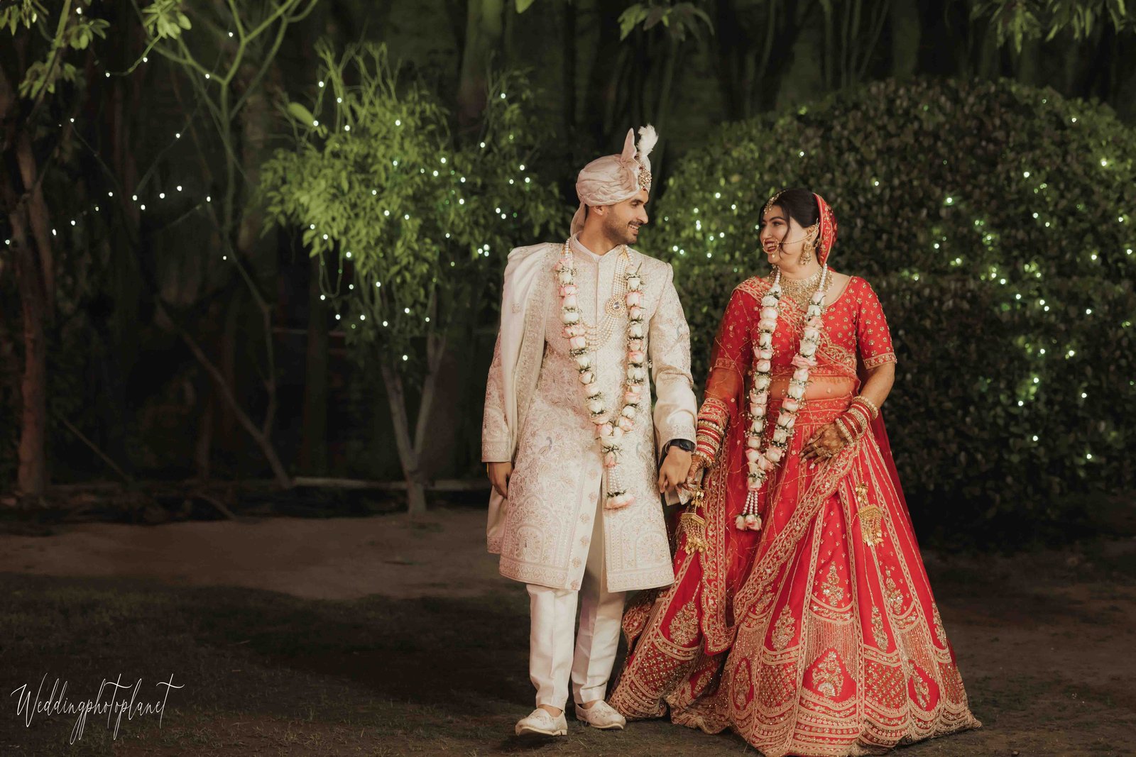 Groom holding bride’s hand during entry